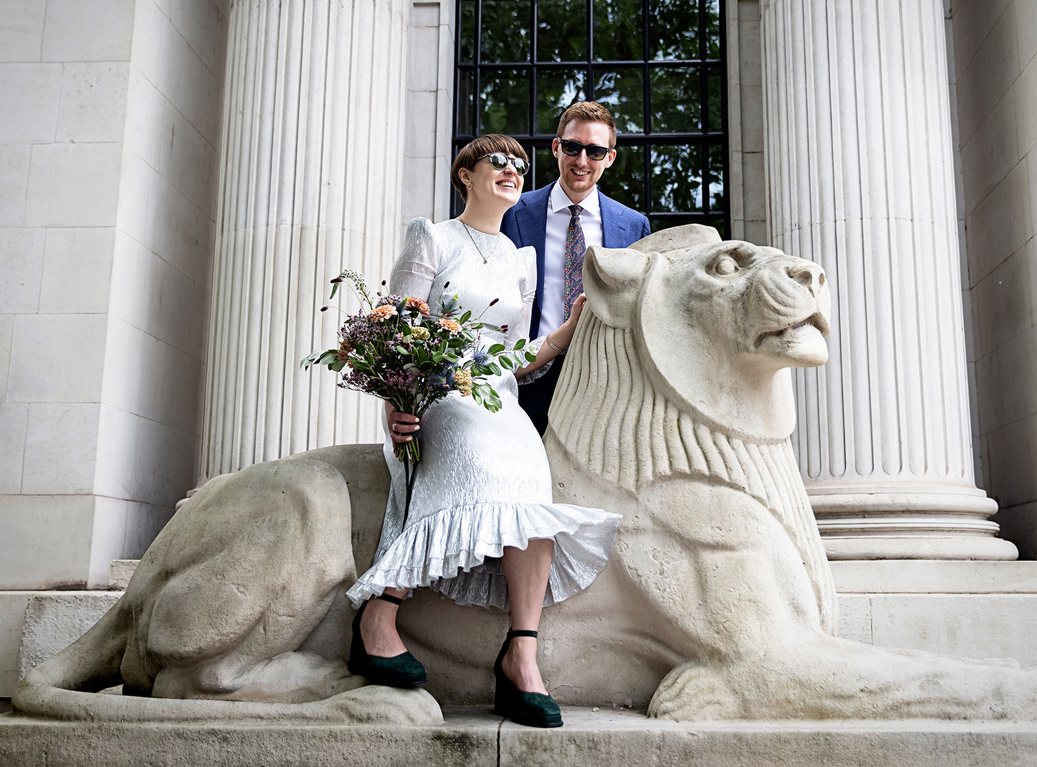 Bride-and-groom-laugh-on-lion-statue-Old-Marylebone-Town-Hall-wedding-close-small (listing)