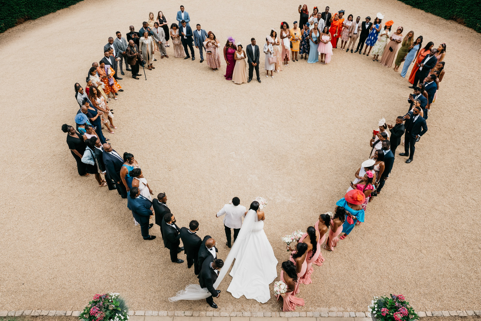 A fairytale wedding party standing in a heart shape. (listing)