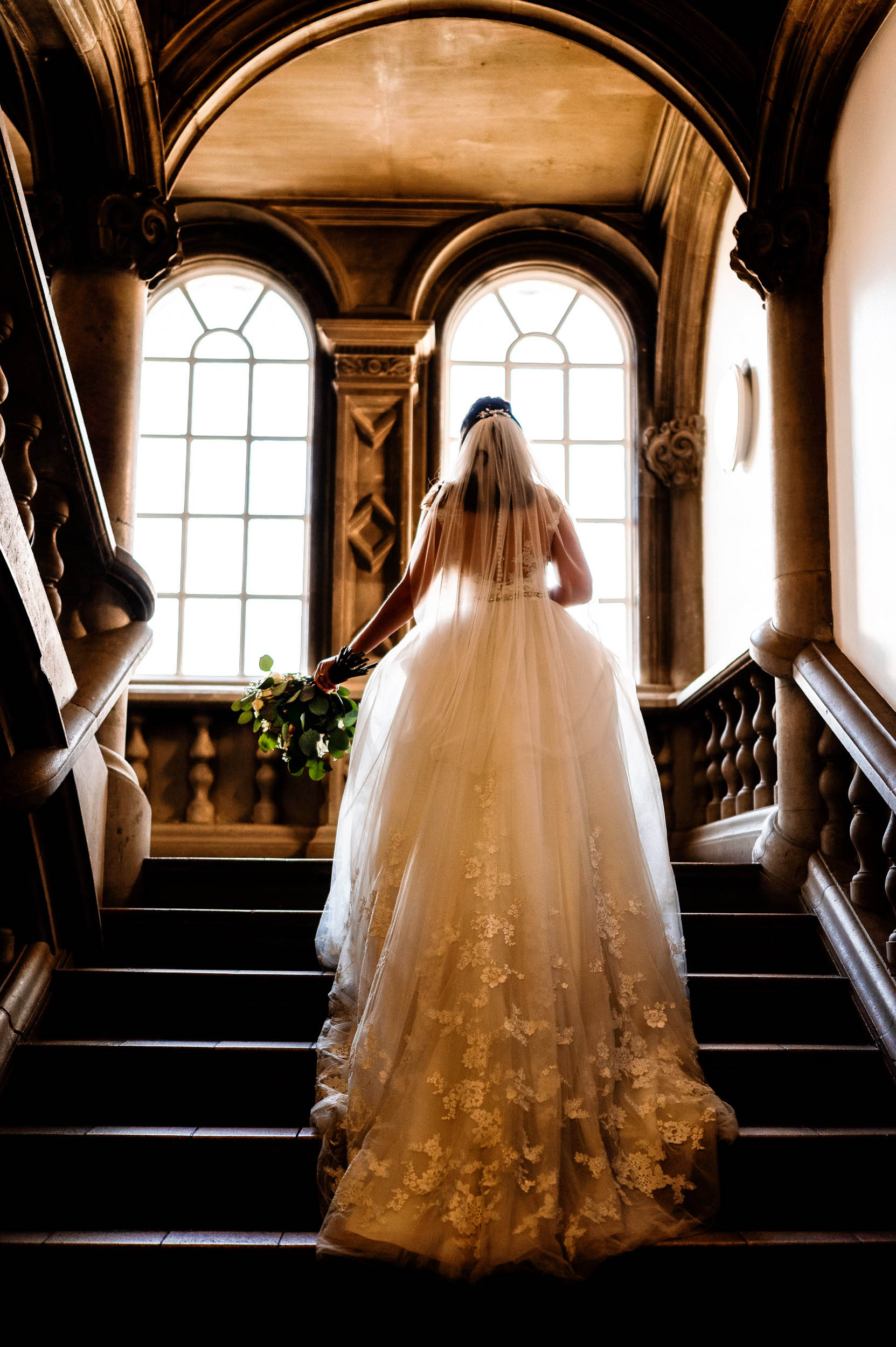 A bride is walking down the stairs on her wedding day in London. (listing)