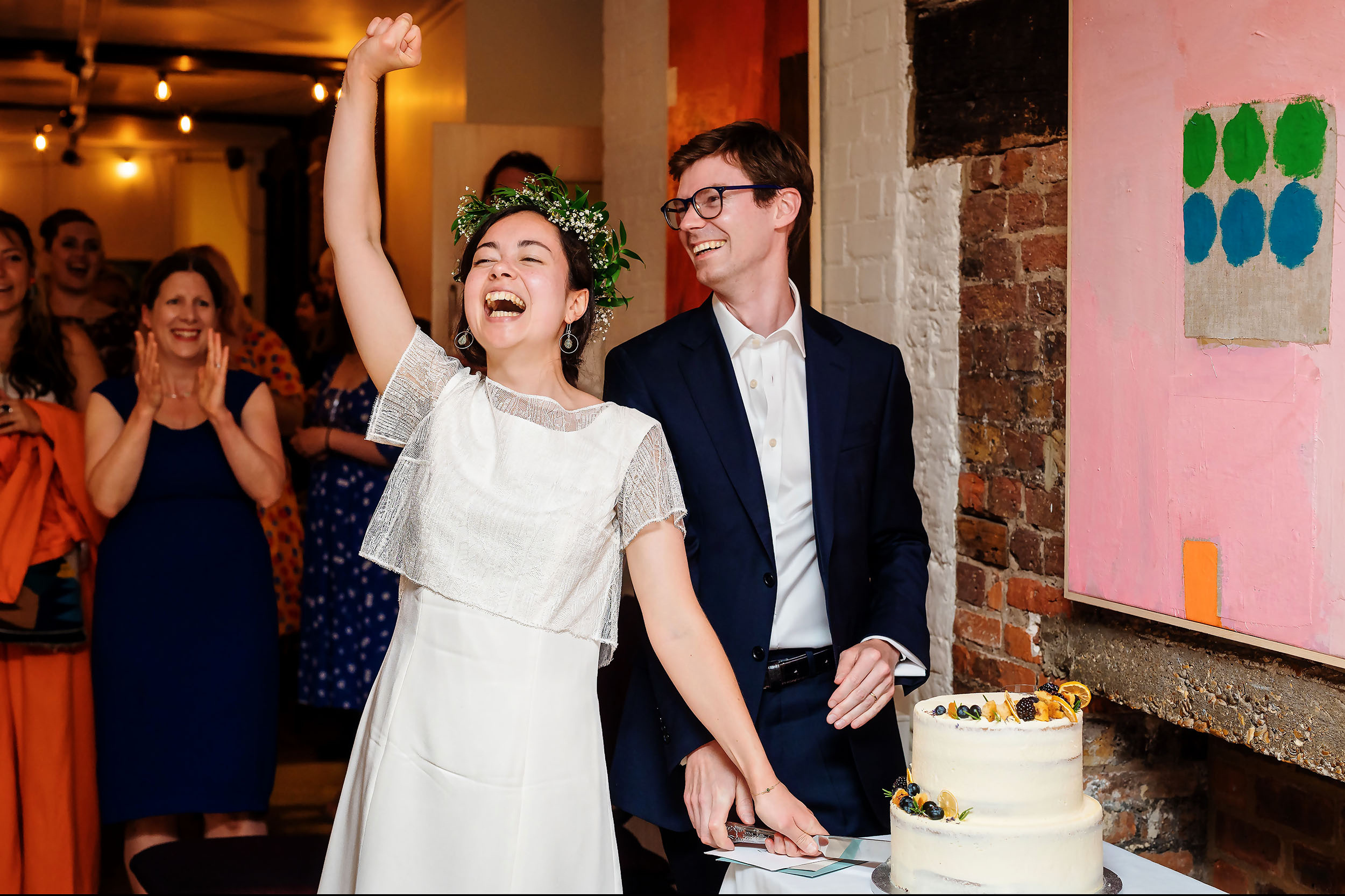 A couple cutting their wedding cake at a cheap wedding in London. (listing)