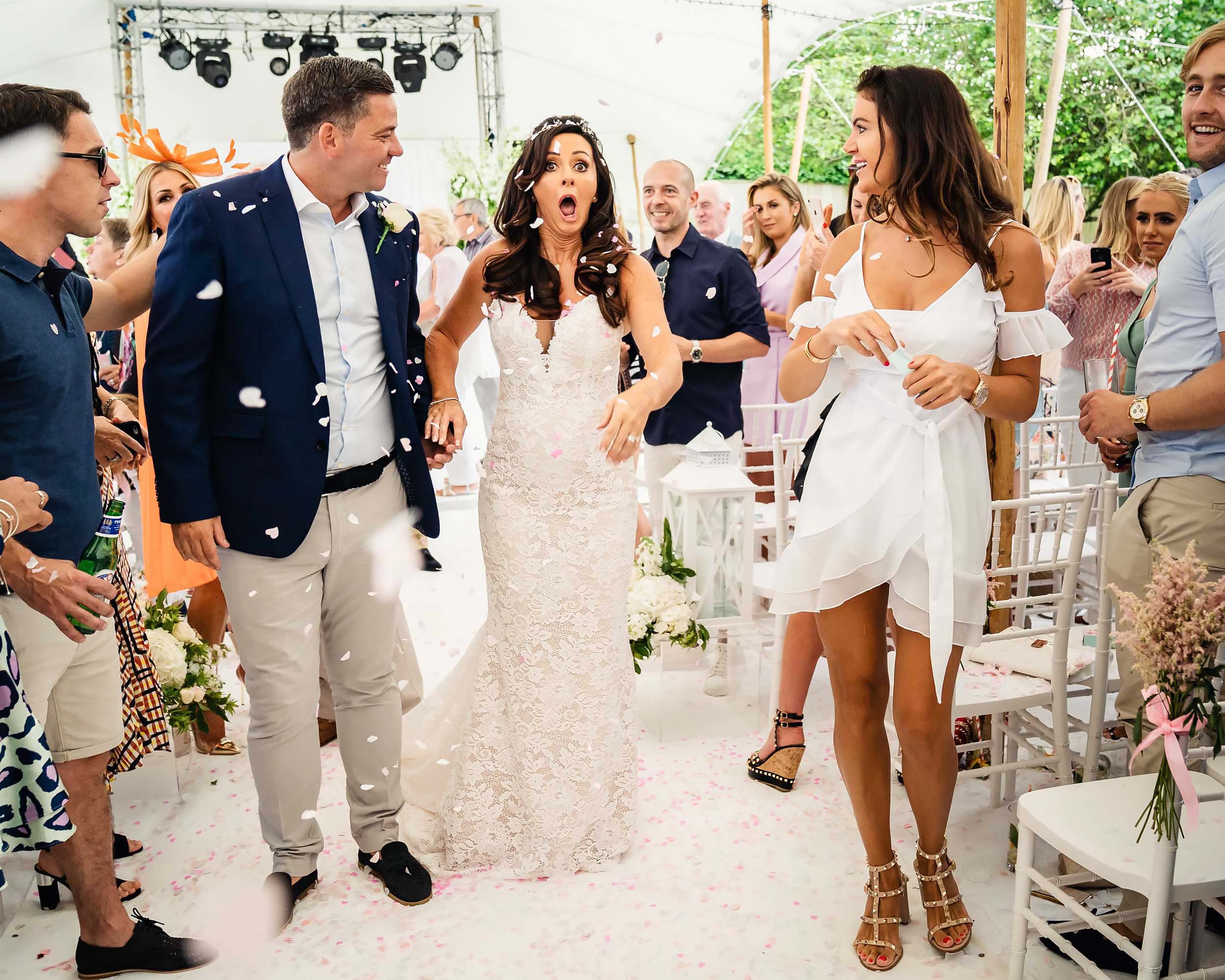 A bride and groom walk down the aisle with affordable wedding photographer capturing their London ceremony. (listing)