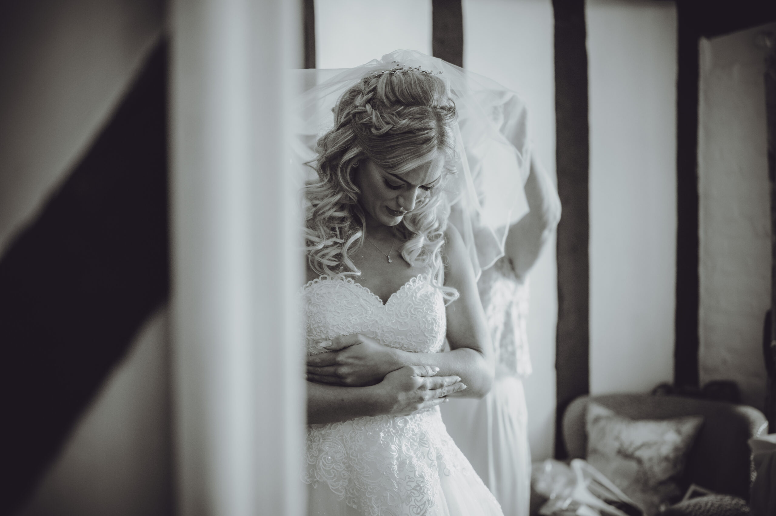 A bride is getting ready for her wedding in a black and white photo. (listing)