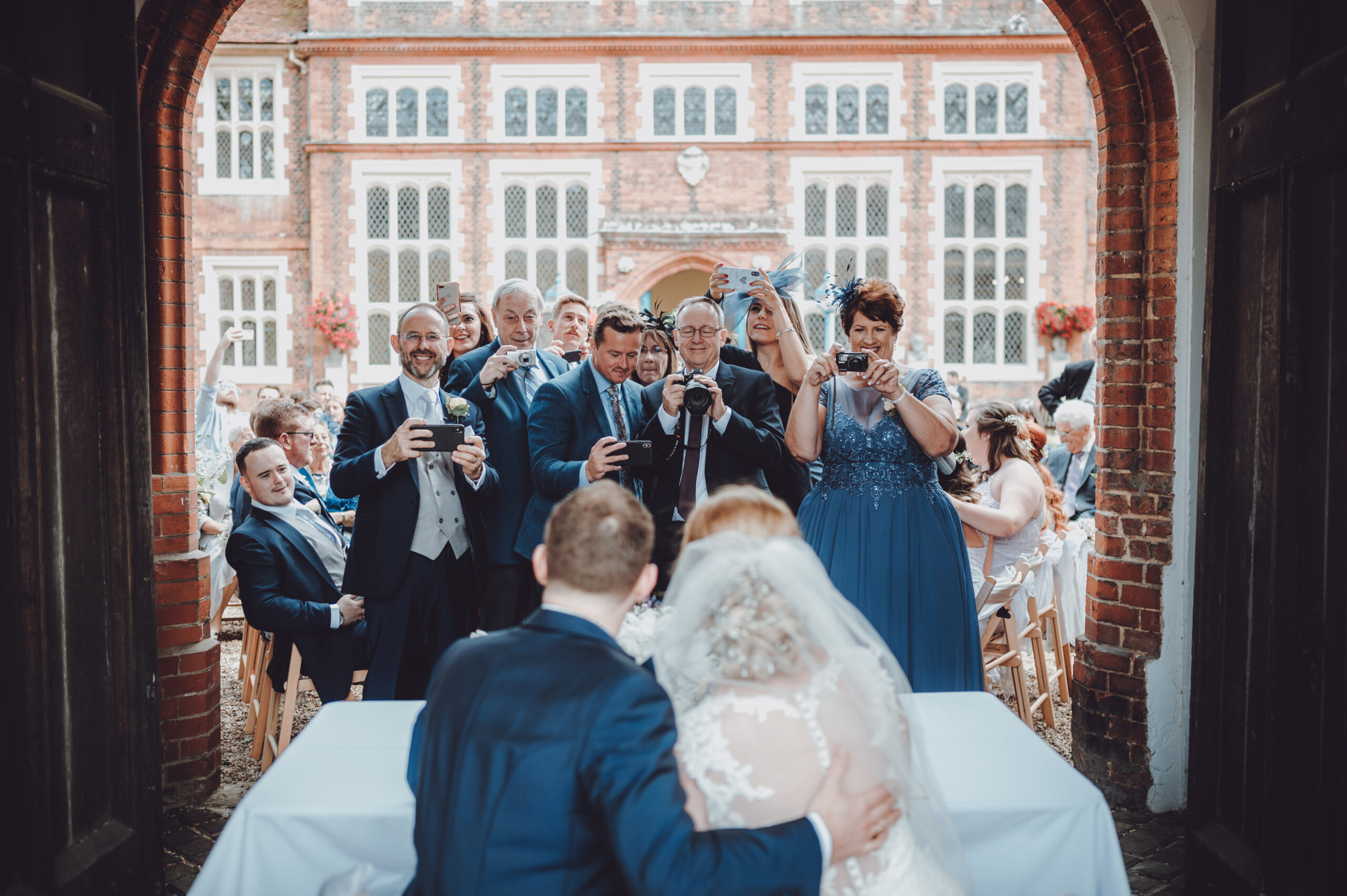 A bride and groom are getting married in front of their wedding party. (listing)