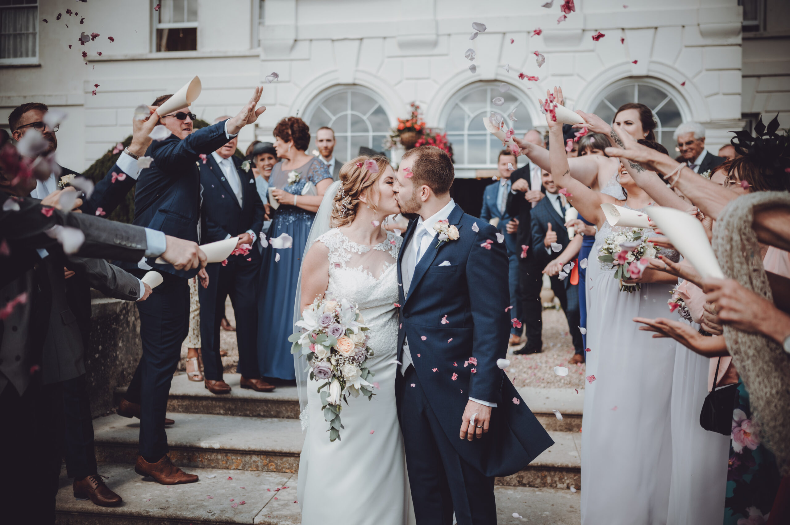 A bride and groom kissing in front of confetti. (listing)