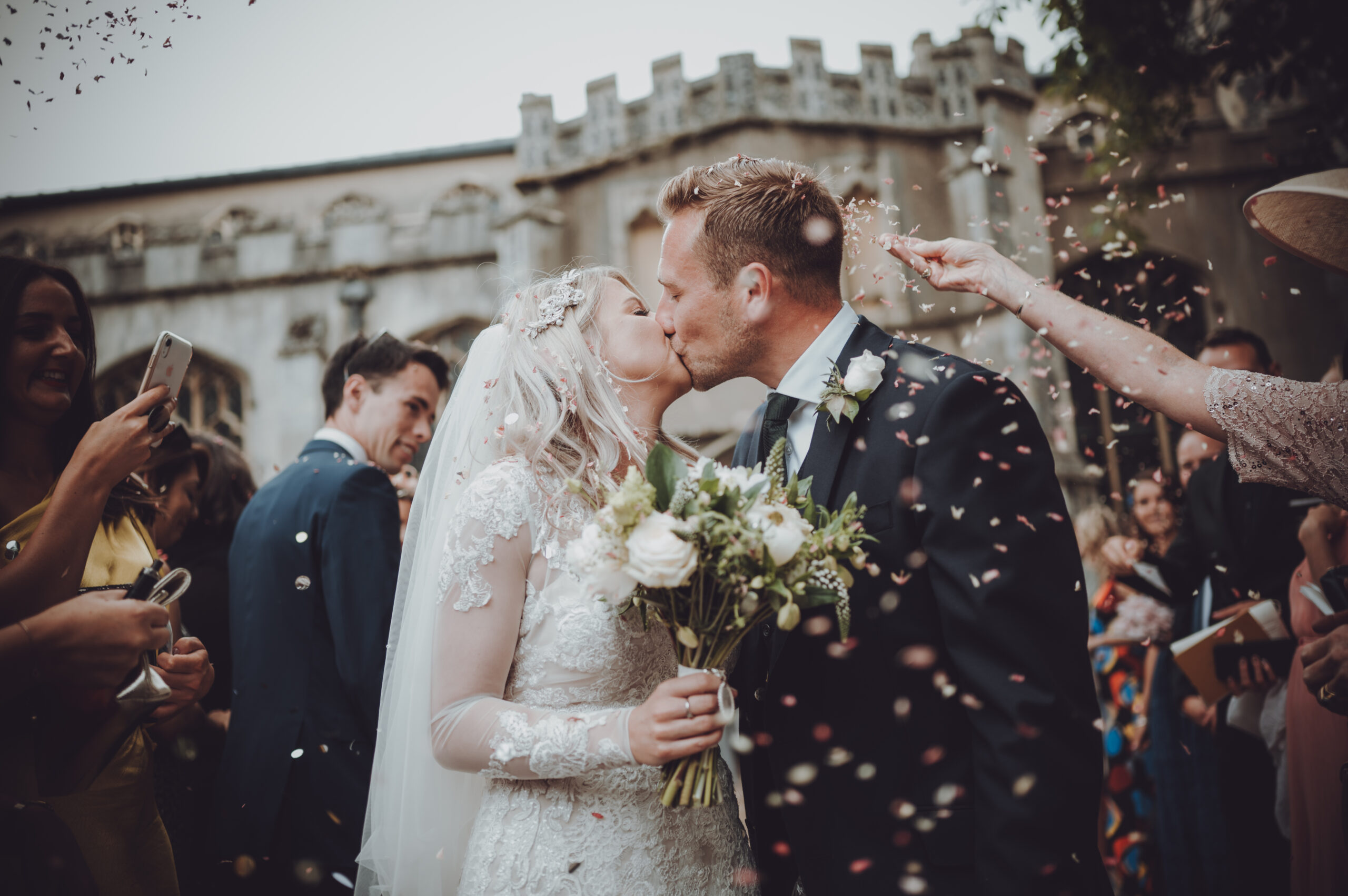 A bride and groom kissing in front of confetti. (listing)