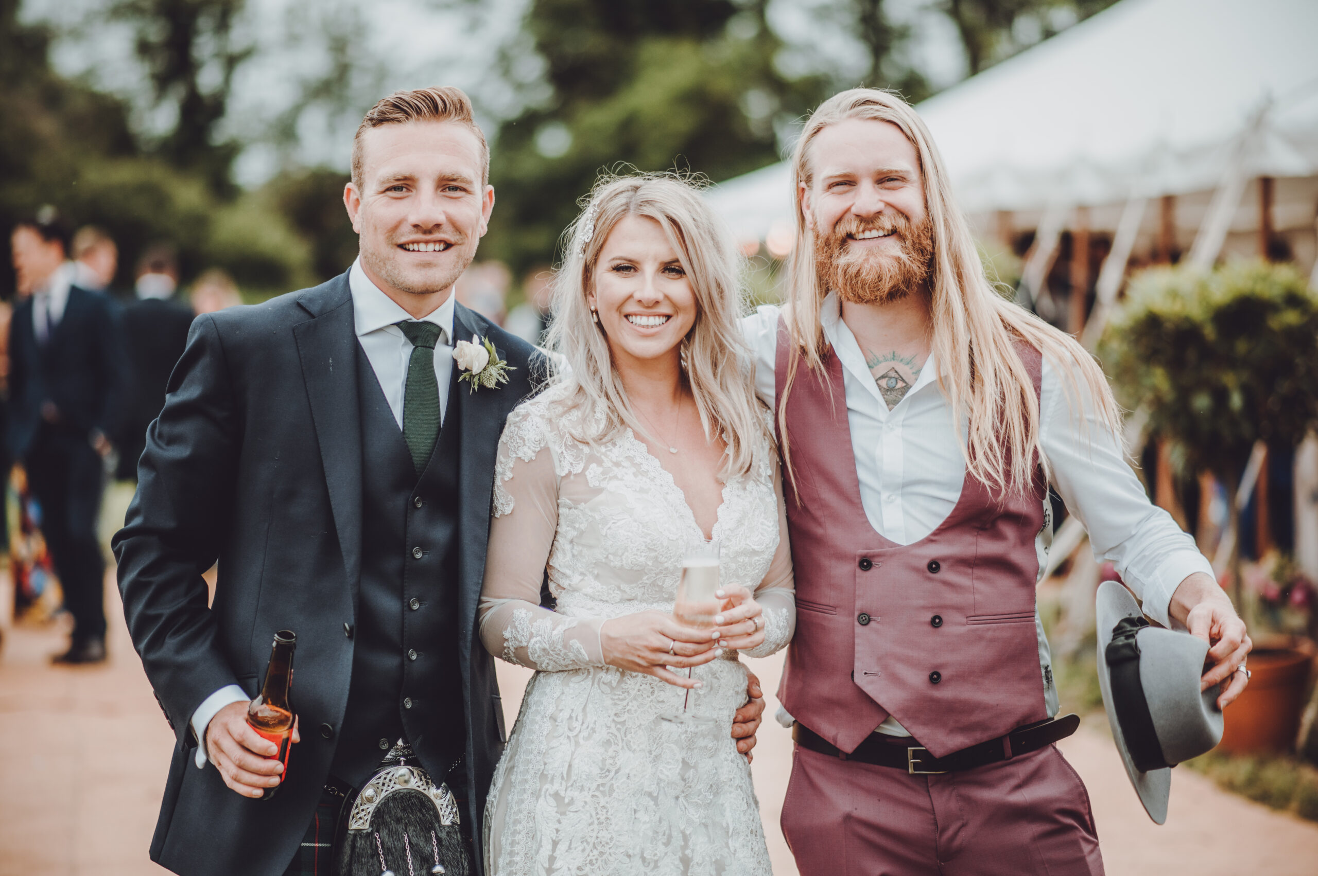 A bride and groom pose for a photo in a tent. (listing)