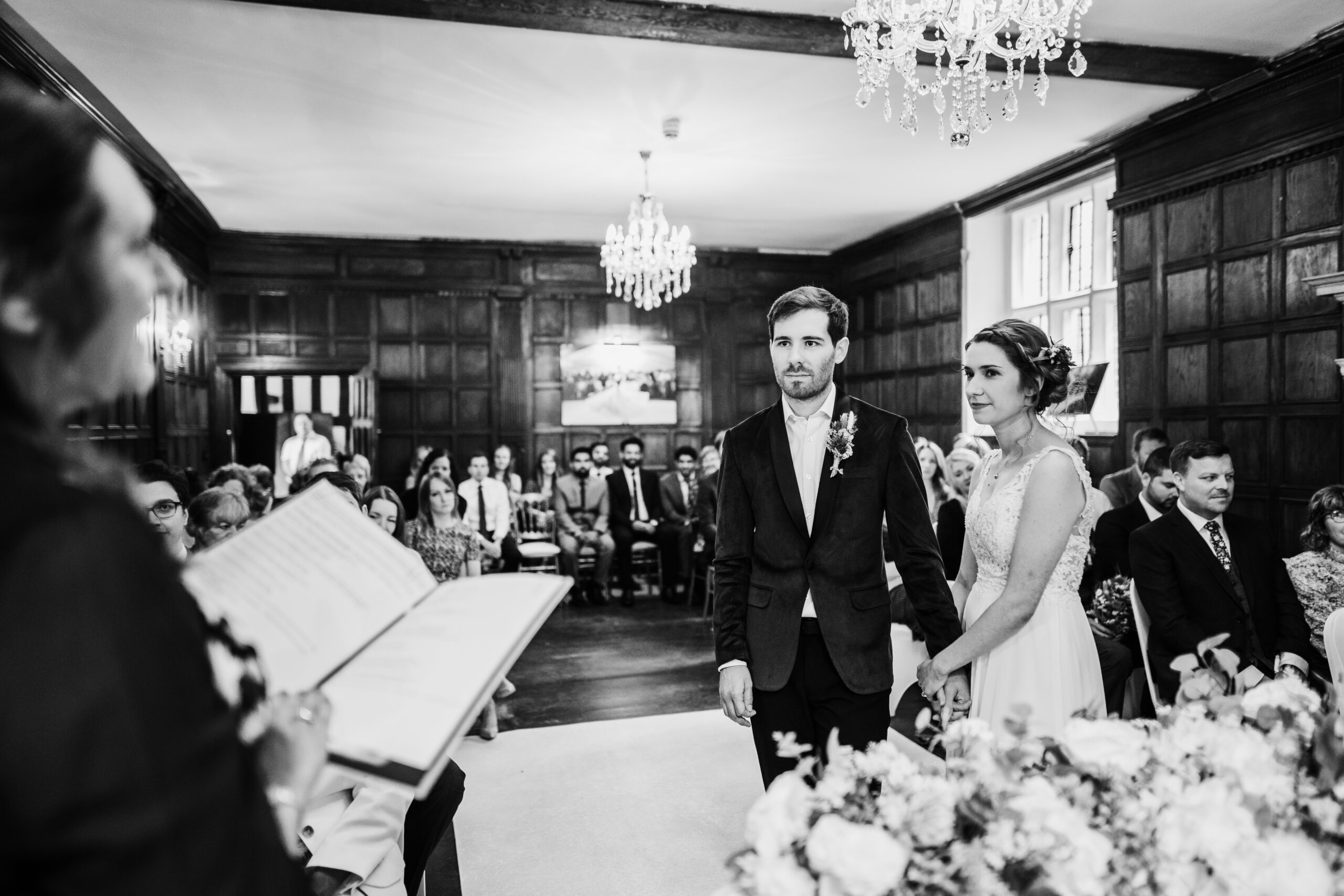 A black and white photo of a bride and groom walking down the aisle. (listing)