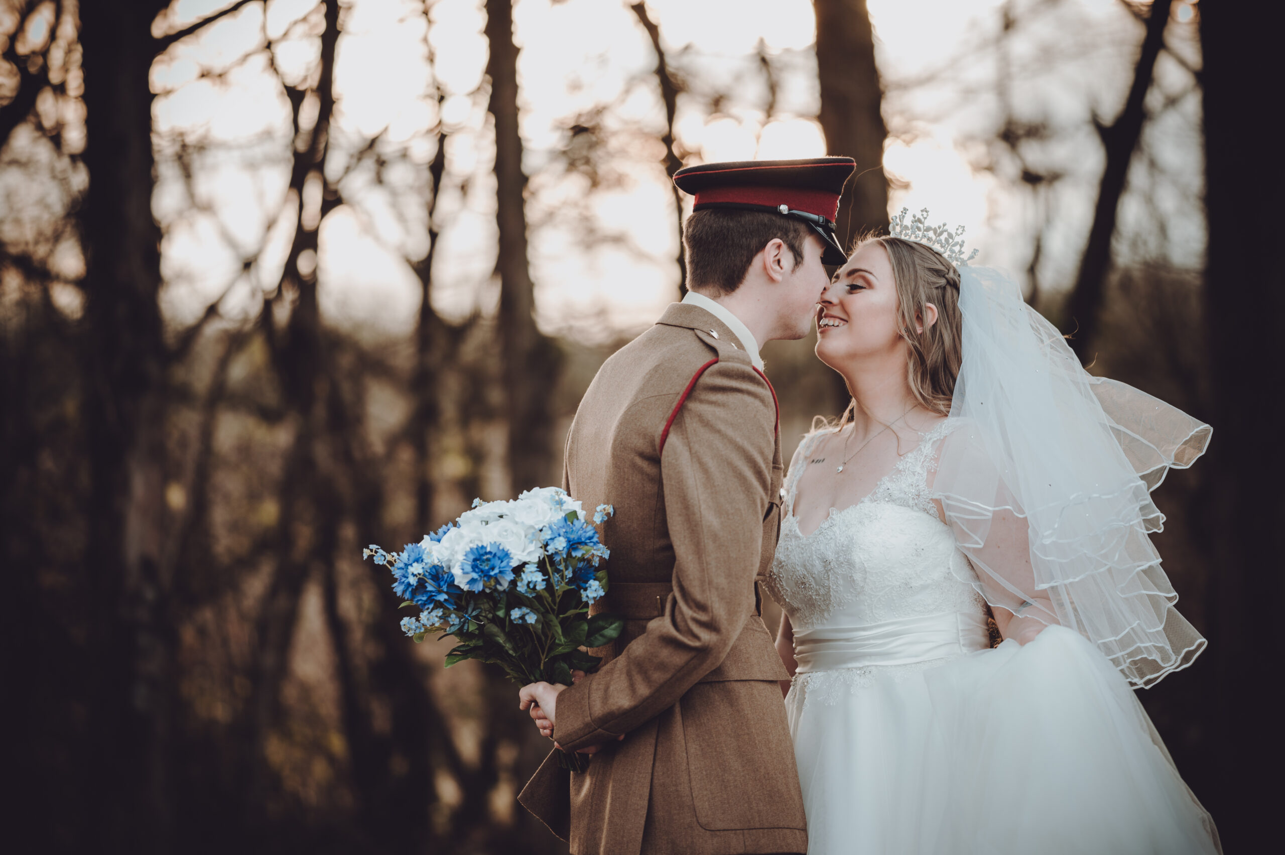 A bride and groom kissing in the woods. (listing)