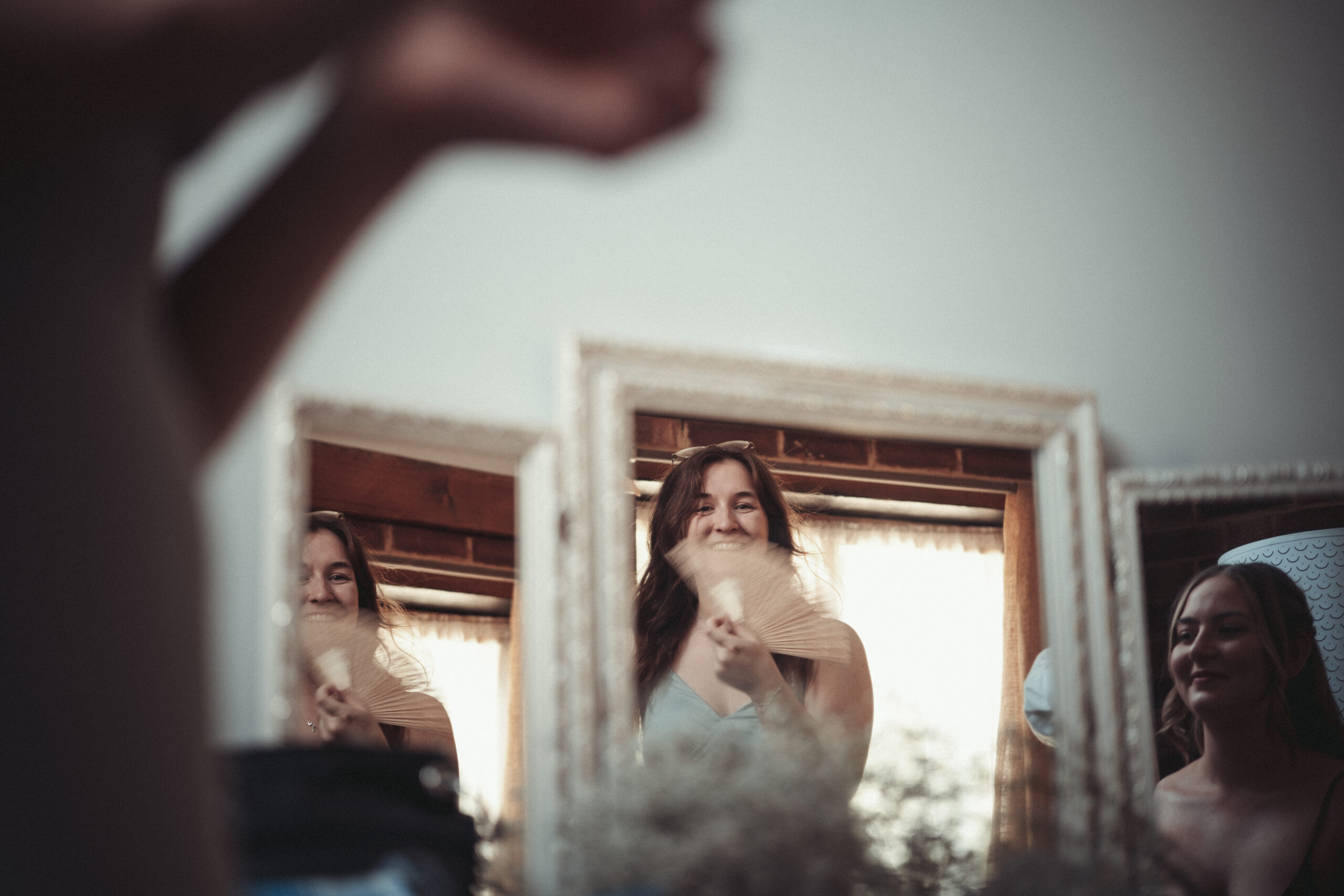 A woman is smiling in front of a mirror. (listing)