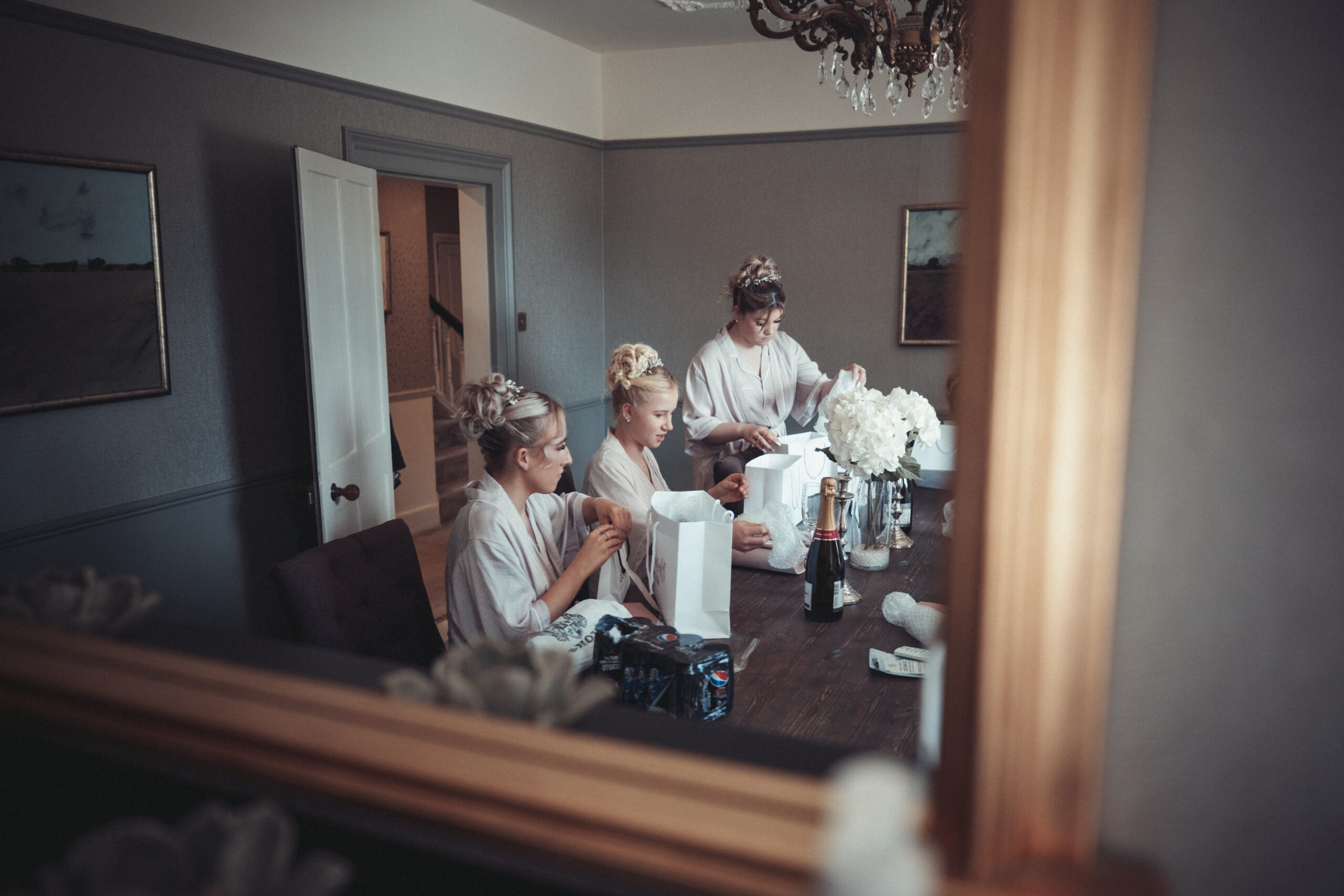 Bridesmaids getting ready in a mirror. (listing)