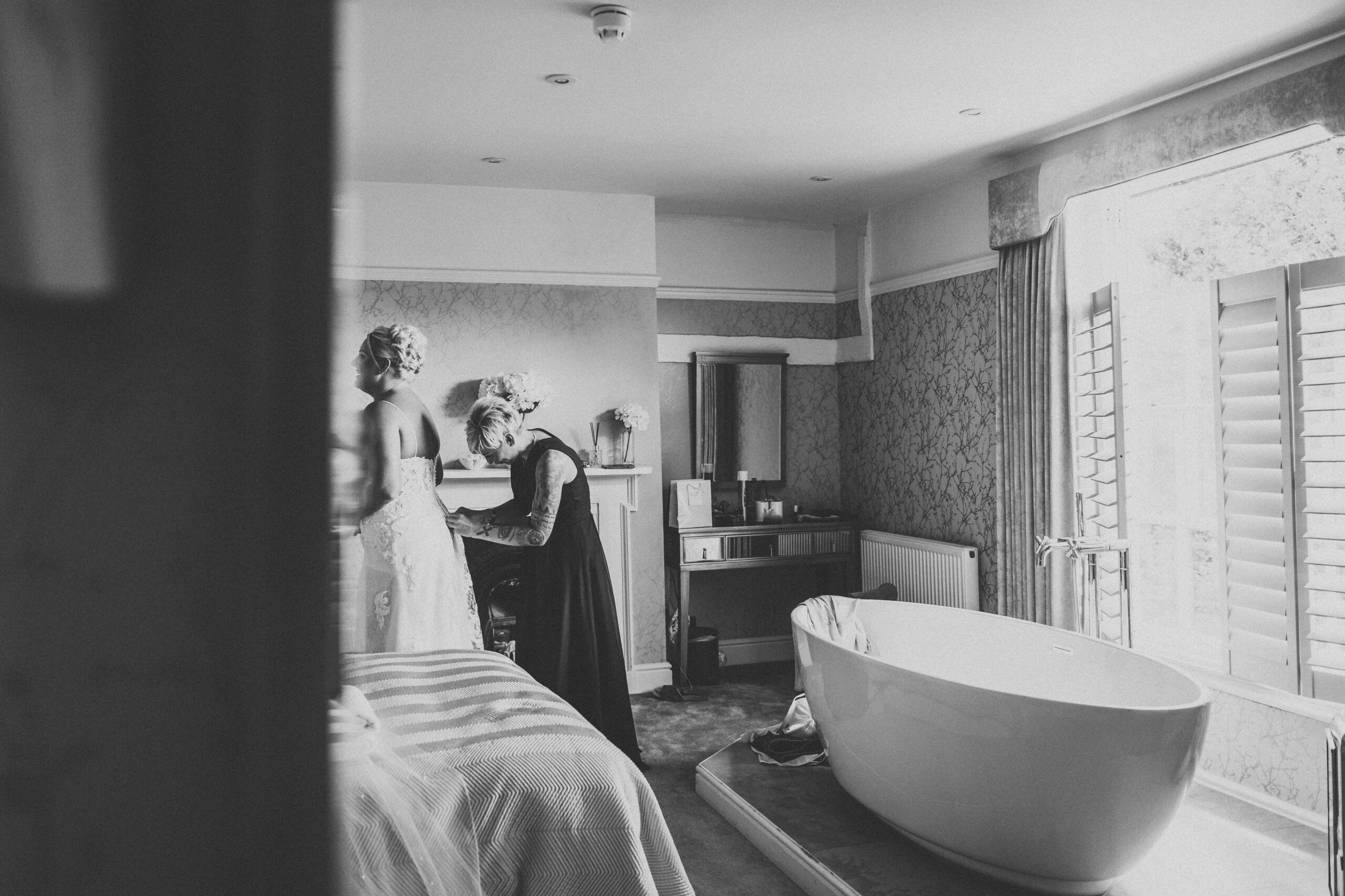 A bride getting ready in a room with a bathtub. (listing)