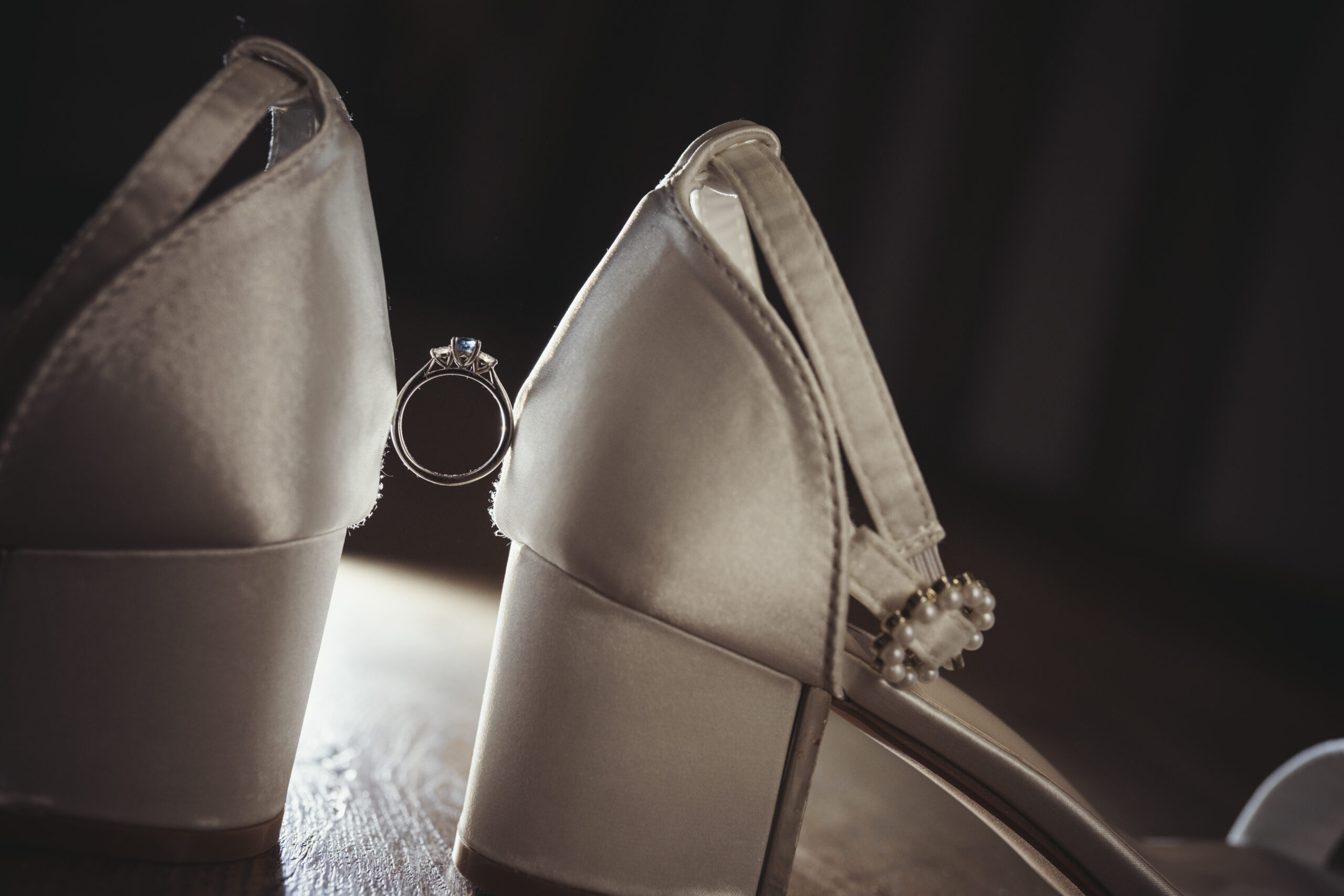 A pair of wedding shoes with a wedding ring on them. (listing)