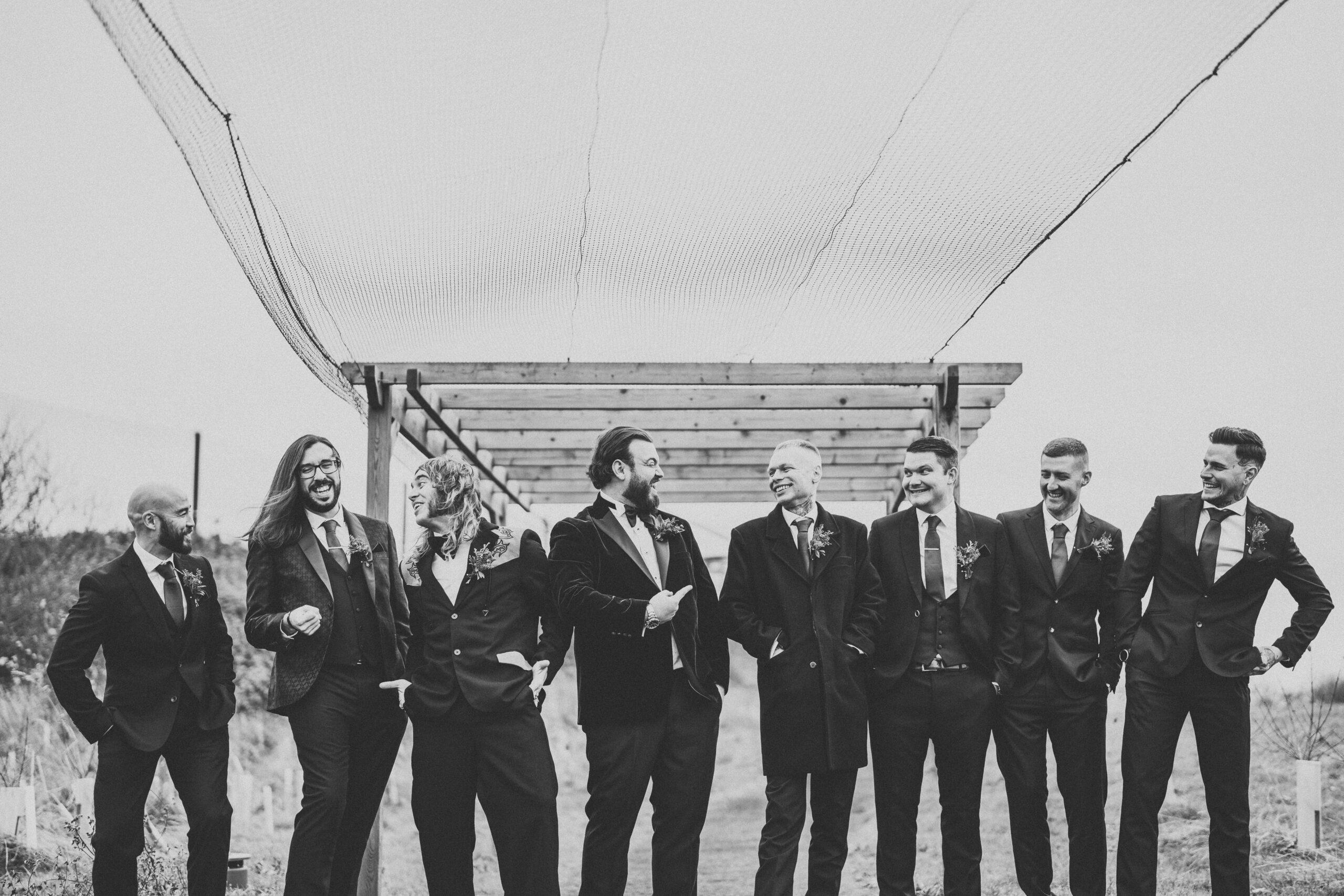 A black and white photo of a group of groomsmen. (listing)