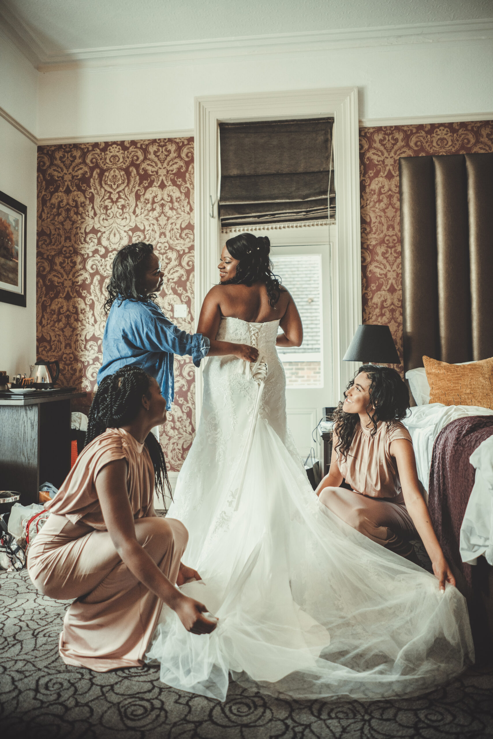 A bride and her bridesmaids are getting ready in a hotel room. (listing)