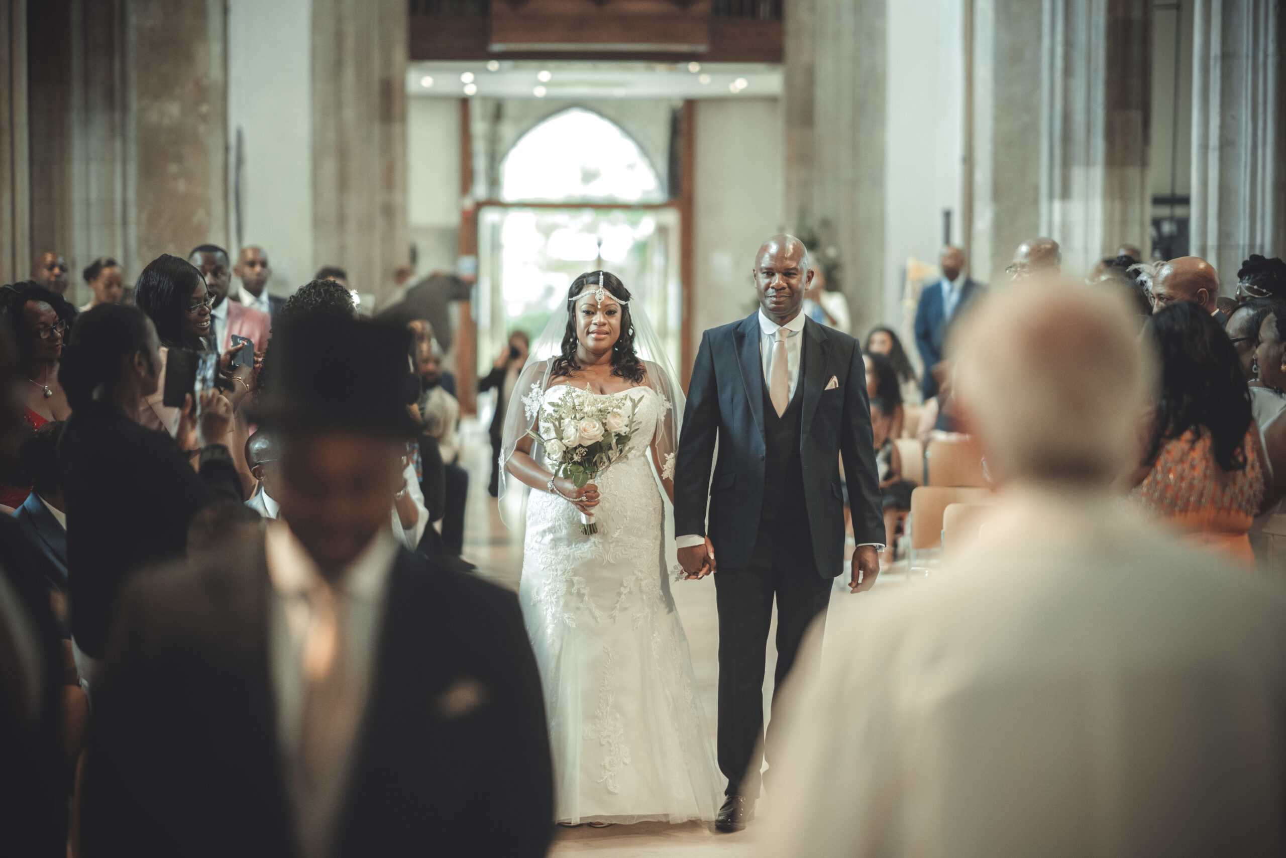 A bride and groom walking down the aisle of a church. (listing)