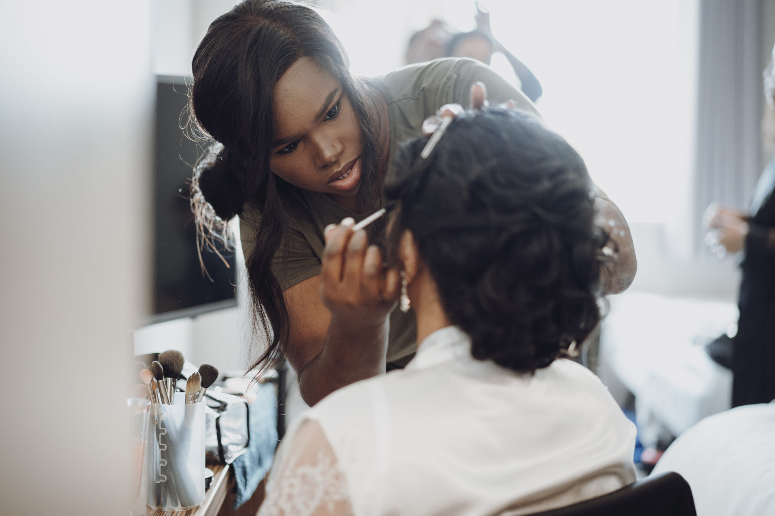 A woman getting her makeup done in a hotel room. (listing)