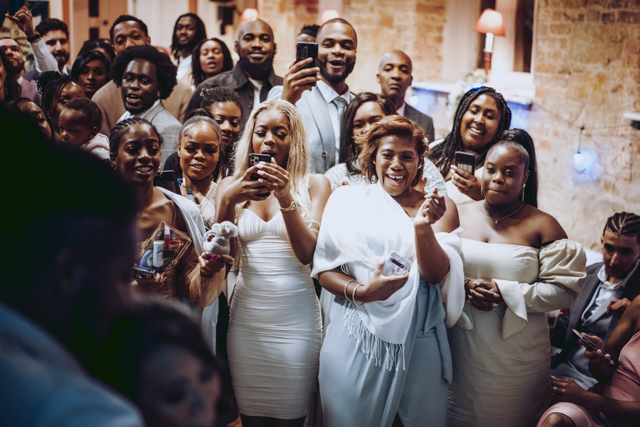 A group of people posing for a photo at a wedding reception. (listing)