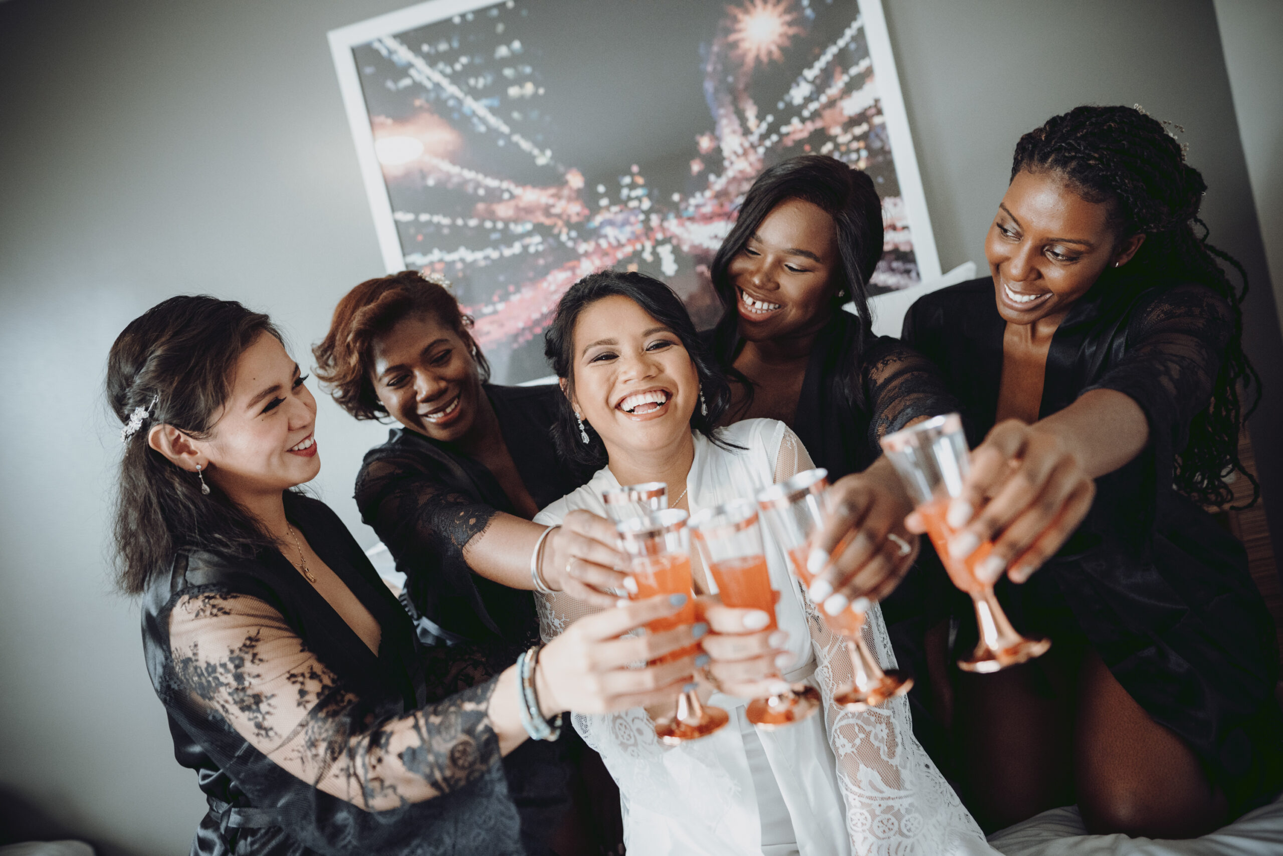 A group of bridesmaids toasting with champagne glasses. (listing)