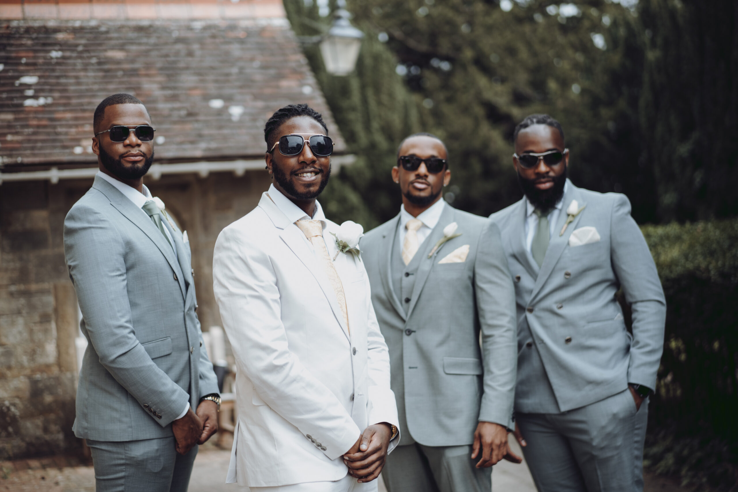 A group of groomsmen in suits posing for a photo. (listing)