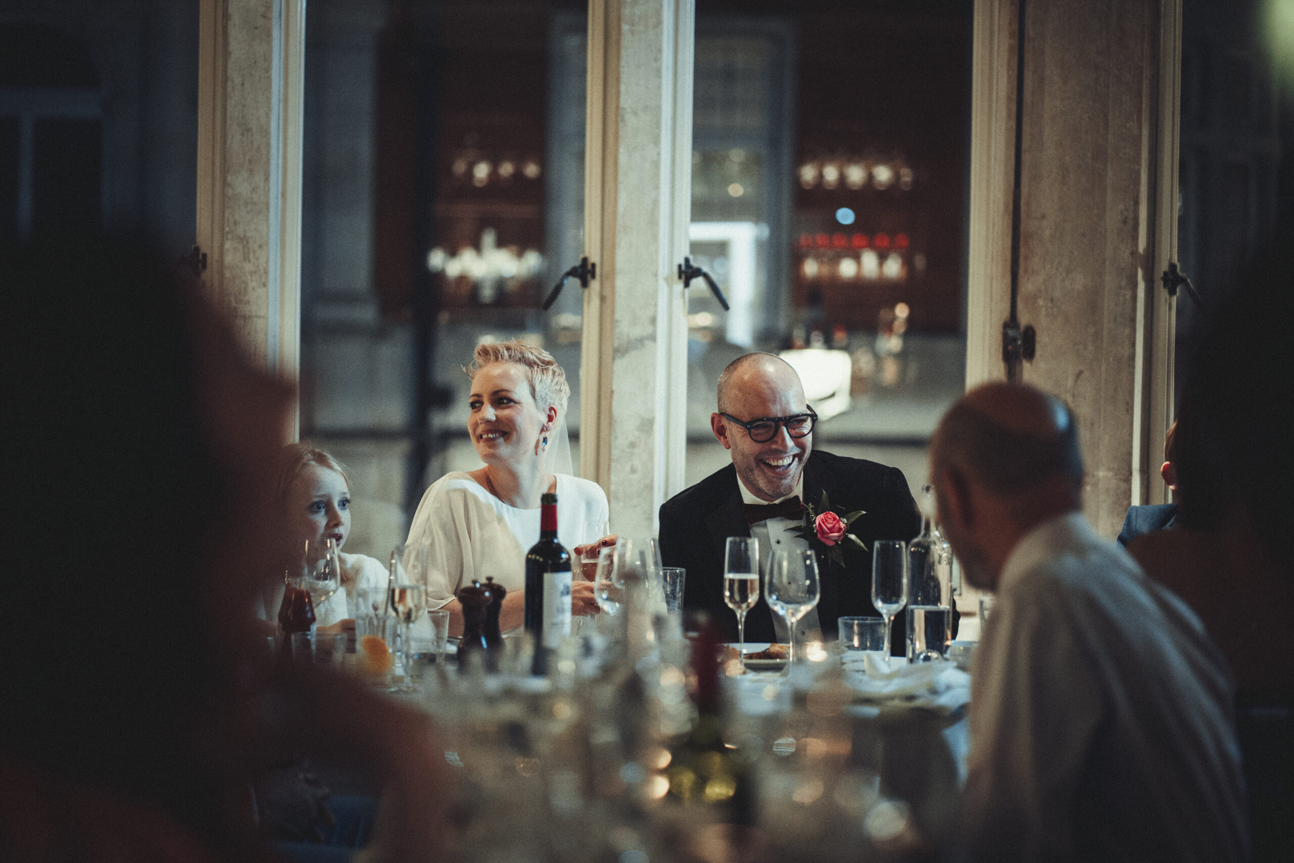 A group of people sitting at a table at a wedding. (listing)
