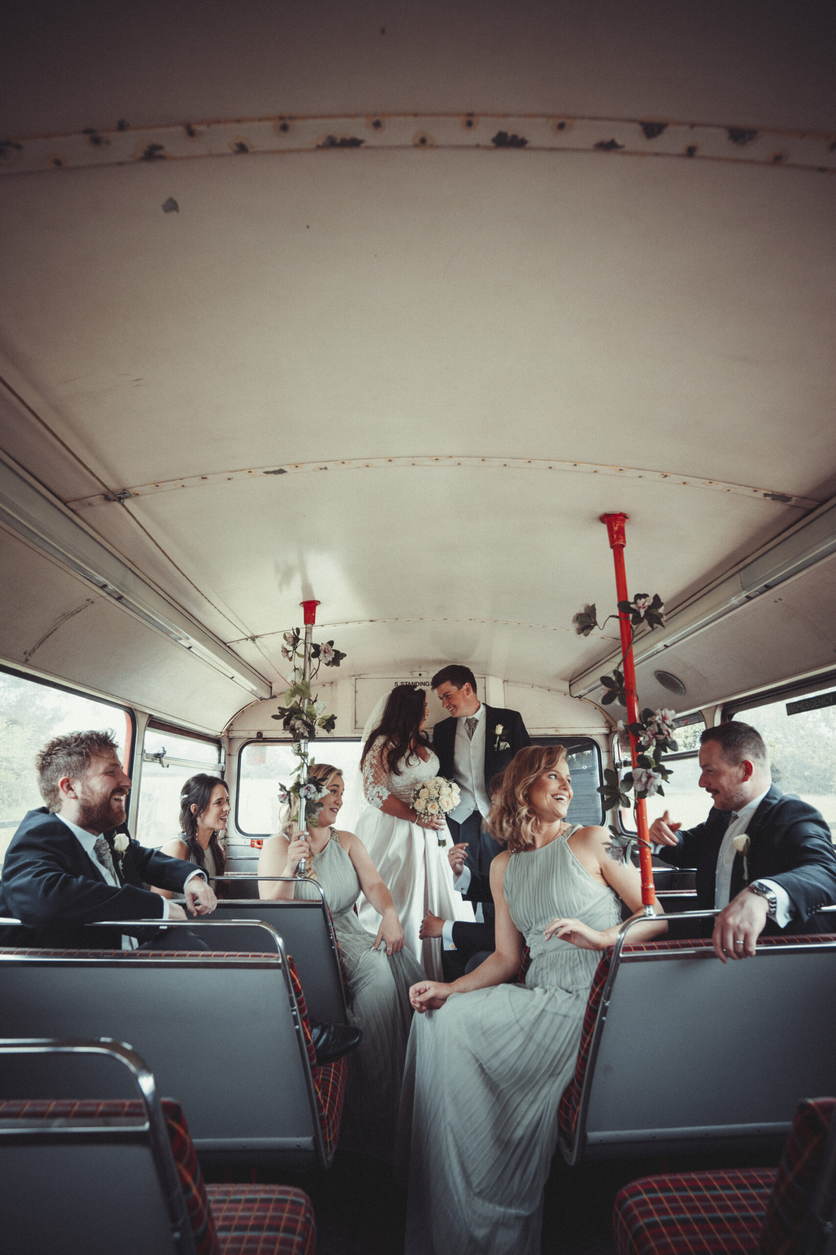 A group of bridesmaids and groomsmen on a bus. (listing)